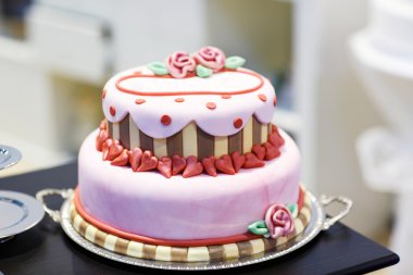 Düğün pastası pembe Gül çiçek ve kalpleri ile dekore edilmiştir. .