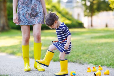 Anne ve küçük sevimli kız sarı kauçuk botlar