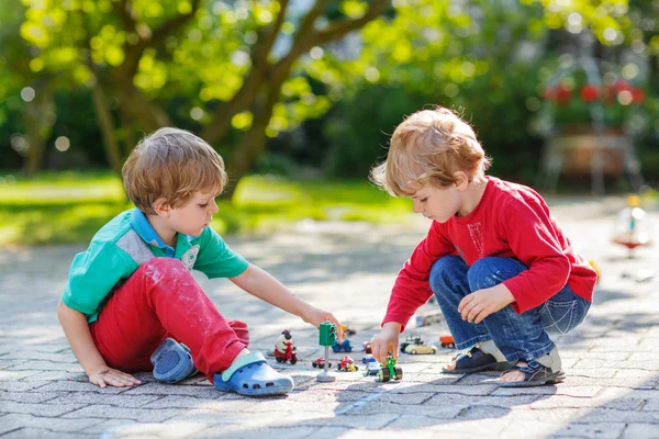 Two little boys playing with car toys — Stock Photo, Image