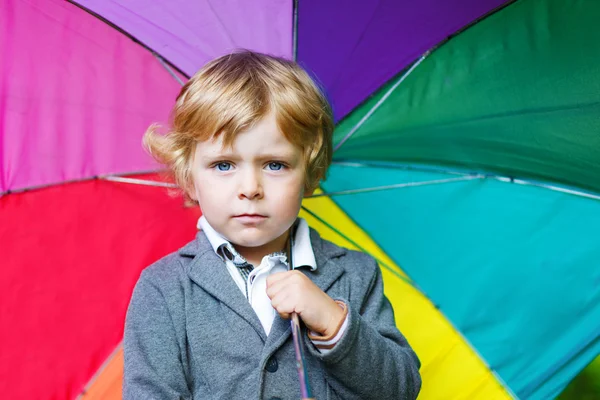 Pequeno menino bonito da criança com guarda-chuva colorido e botas, outdoo — Fotografia de Stock