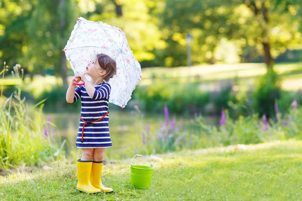 Adorable niño pequeño en botas de lluvia amarillas y paraguas en summe —  Fotos de Stock