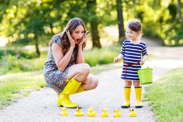 Madre e piccolo adorabile bambino in stivali di gomma gialla — Foto Stock