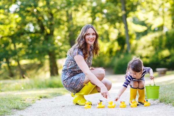 Mother and little adorable daughter in yellow rubber boots — Stock Photo, Image