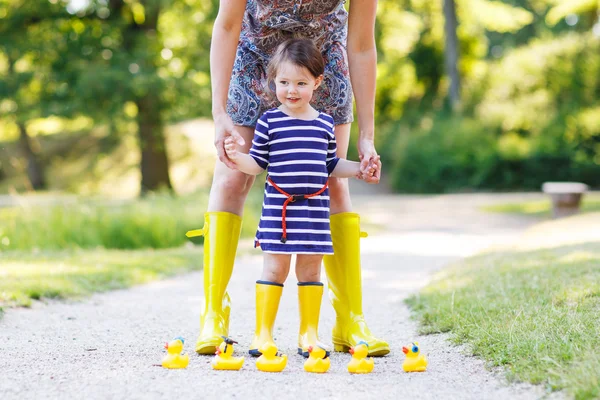 Madre e piccola adorabile figlia in stivali di gomma gialla — Foto Stock