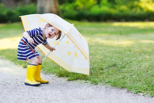 Adorable little child in yellow rain boots and umbrella in summe — Stock Photo, Image