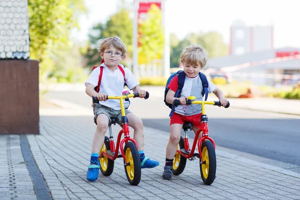 两个兄弟姐妹小孩开心骑自行车在市工程 — 图库照片