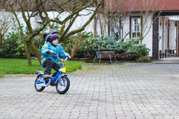 Criança de três anos andando de bicicleta no outono ou winte — Fotografia de Stock