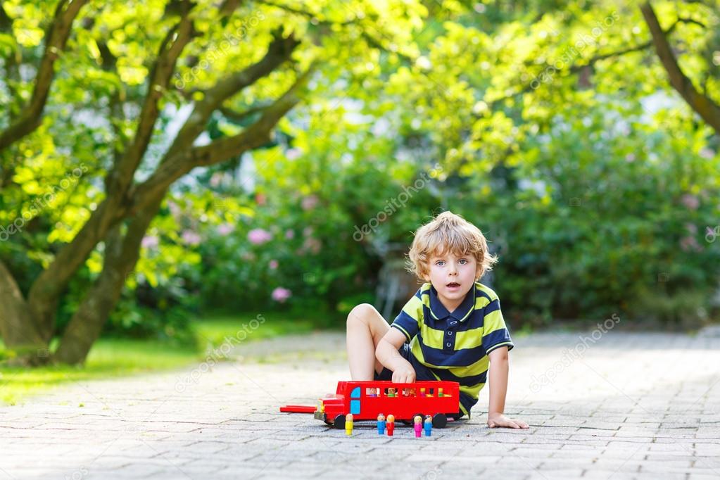 Little preschool boy playing with car toy