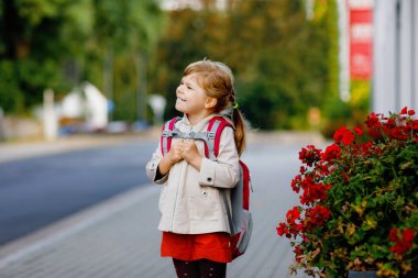 Anaokuluna giden tatlı küçük bir kız. Sağlıklı bir çocuk anaokuluna ve anaokuluna doğru yürüyor. Şehir caddesinde, açık havada sırt çantalı mutlu bir çocuk..