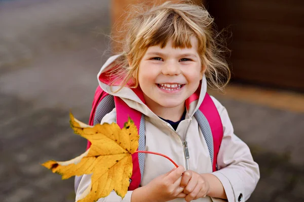 Petite fille mignonne tout-petit sur son premier jour d'aller à l'école de jeu. Enfant heureux et en bonne santé se rendant à l'école maternelle. Enfant avec sac à dos allant à la garderie dans la rue de la ville, à l'extérieur — Photo