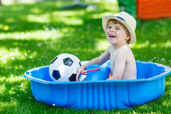 Menino pequeno se divertindo com água espirrando no verão gar — Fotografia de Stock