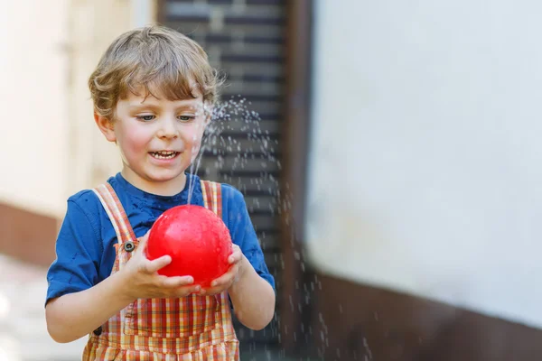 Little toddler boy having fun with splashing water in summer gar — Stock Photo, Image