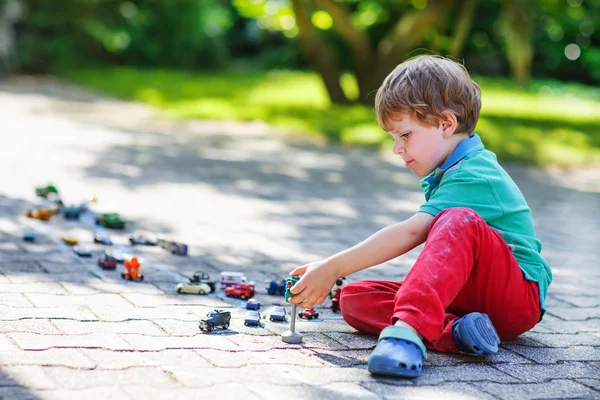 Piccolo bambino ragazzo giocare con auto giocattolo — Foto Stock