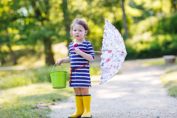 Adorable niño pequeño en botas de lluvia amarillas y paraguas en summe —  Fotos de Stock