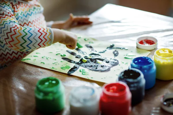 Closeup of little creative toddler girl painting with finger colors an owl bird. Child having fun with drawing at home, in kindergaten or preschool. Games, education and distance learning for kids. — Stock Photo, Image