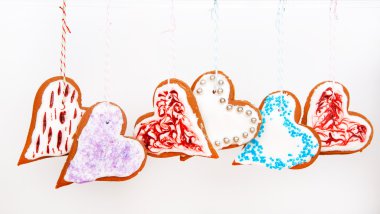 Beyaz arka plan üzerinde asılı gingerbread kalp kurabiye.