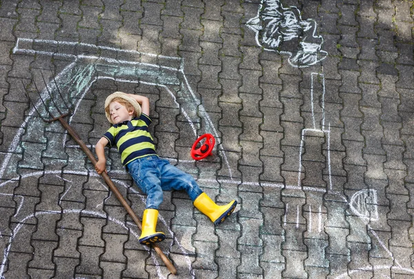 Little boy having fun with tractor picture drawing with chalk — Stock Photo, Image