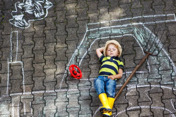 Little boy having fun with tractor picture drawing with chalk — Stock Photo, Image