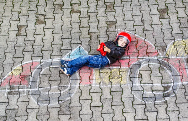 Kleiner Junge hat Spaß mit Rennwagen-Bild-Zeichnung mit Kreide — Stockfoto