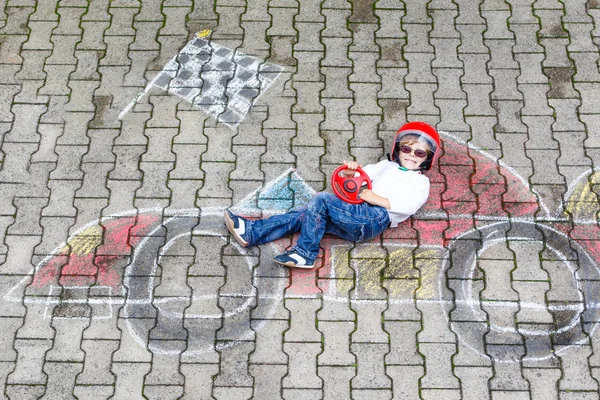 小男孩玩的愉快和用粉笔绘制的种族汽车图片 — 图库照片