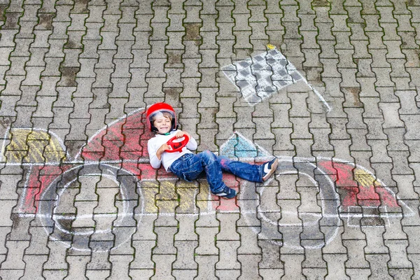 Niño divirtiéndose con el dibujo de la imagen del coche de carreras con tiza —  Fotos de Stock