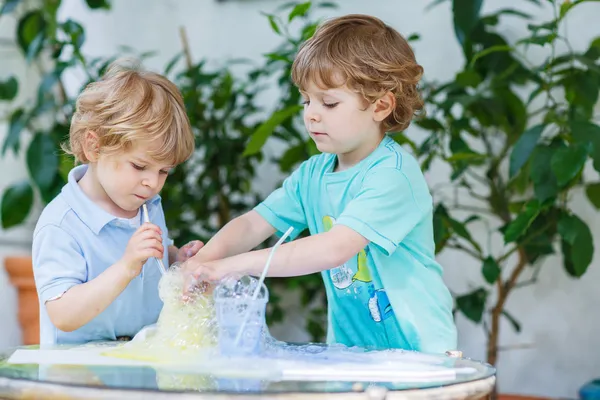 Twee schattige jongens maken experiment met kleurrijke bubbels — Stockfoto