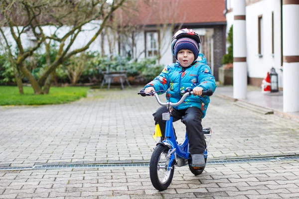 Lycklig pojke tre år ridning på cykel i höst eller vinter, — Stockfoto