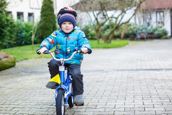 Klein kind van drie jaar rijden op een fiets in de herfst of winte — Stockfoto