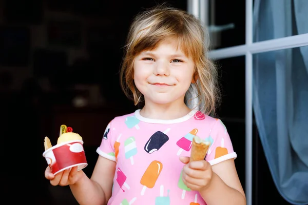 Menina pré-escolar engraçado bonito comer sorvete de frutas em casa. Criança infantil saudável feliz sorrindo e degustando sorvete em cone de waffle. Criança adorável desfrutando de sobremesa de verão. — Fotografia de Stock