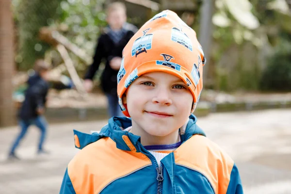 Ritratto all'aperto di bambino in primavera o autunno vestiti colorati. Ragazzo felice che si diverte in uno zoo. Bambino sorridente — Foto Stock