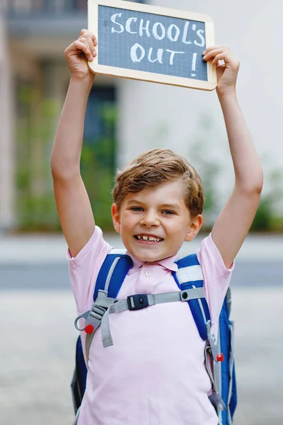 Glücklicher kleiner Junge mit Rucksack oder Schulranzen. Schulkind auf dem Schulweg. Gesundes entzückendes Kind im Freien Mit Kreidetisch für Kopierraum. Zurück zur Schule oder zur Schule. — Stockfoto