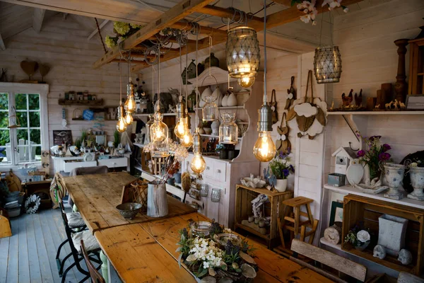 Beautiful arrangement of wooden decor and ceramic decoration in a shop for indoor, outdoor and garden. Light bulb as fairy lights. — Stock Photo, Image