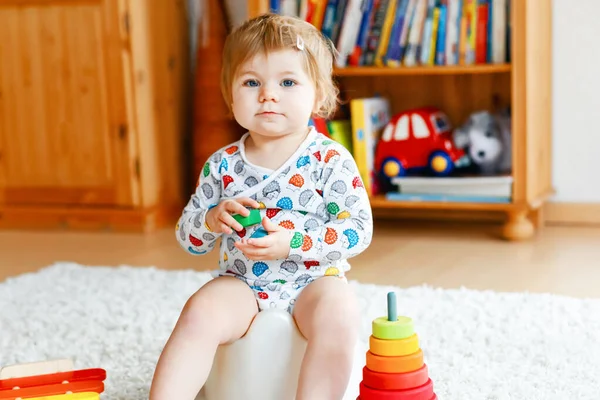 Primer plano de lindo niño pequeño de 12 meses de edad bebé niña sentada en el orinal. —  Fotos de Stock