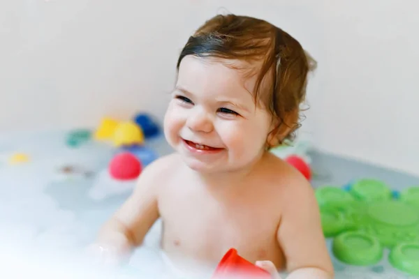 Schattig schattig baby meisje neemt schuimig bad in bad. Peuter spelen met bad rubber speelgoed. — Stockfoto