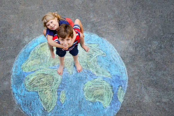 Niña preescolar y niño de la escuela con la pintura globo de tierra con tiza de colores en el suelo. Feliz concepto del día de la tierra. Creación de niños para salvar el mundo, el medio ambiente y la ecología. —  Fotos de Stock
