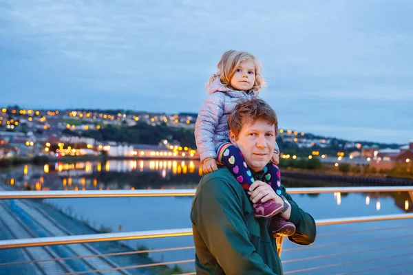 Vackert porträtt av söta små småbarn flicka med far. Glad bebis som kramas med pappa. Underbar familj av man och dotter. Utomhus vid skymningen. — Stockfoto