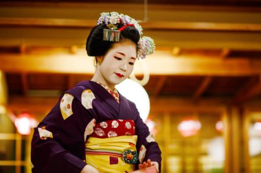 KYOTO, JAPONYA - 18 Mayıs 2015: Japon geleneksel dansını gösteren Maiko çırağı. Maiko bir çırak geyşa. Maikos ozashiki 'deki ziyaretçiler için şarkı söylüyor, shamisen çalıyor veya enstrümanlar çalıyor.