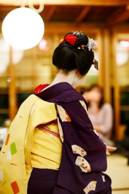 Maiko çırağı Japon geleneksel dansını gösteriyor. Maiko bir çırak geyşa. Maikos ozashiki 'deki ziyaretçiler için şarkı söylüyor, shamisen çalıyor veya enstrümanlar çalıyor.