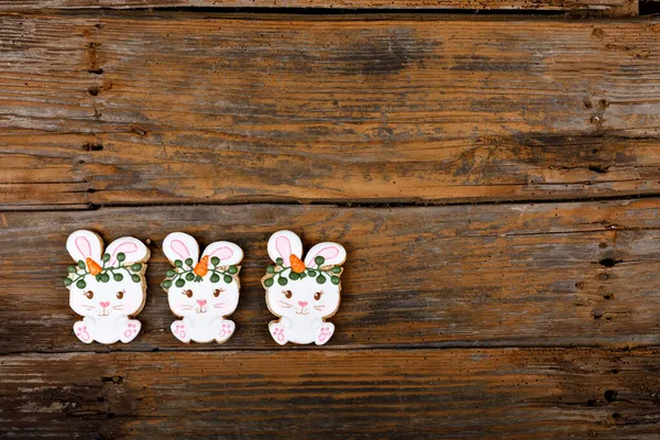 Detailní variace různých velikonočních cukrovinek zdobených královskou polevou. Králík s mrkví na dřevěném pozadí. Krásný sladký dárek nebo pohled — Stock fotografie