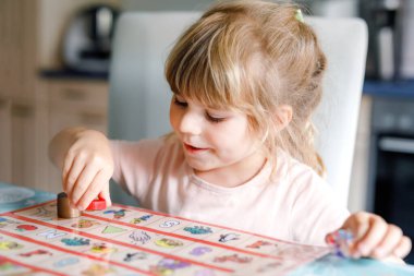 Küçük sevimli kız iskambil oynuyor. Mutlu sağlıklı çocuk hafızasını eğitiyor, düşünüyor. Salgın Coronavirus covid karantina hastalığı sırasında çocuğun evde dinlenmesi ve eğitilmesi