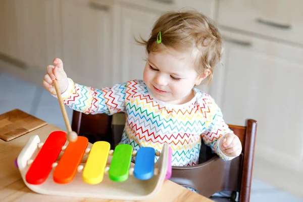 Adorável bonito linda menina brincando com brinquedo educativo de música de madeira em casa. Criança feliz animado aprender a jogar xilofone arco-íris colorido. Educação infantil, atividade para crianças. — Fotografia de Stock