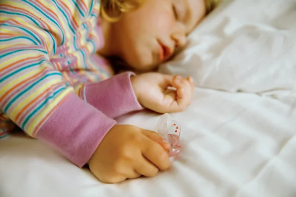 Søt liten småbarnsjente som sover i en stor seng med foreldre. Søte spedbarn som drømmer i hotellseng på familieferier eller hjemme. – stockfoto
