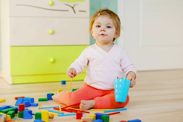 Söt liten flicka leker med pedagogiska leksaker. Glad frisk barn att ha kul med färgglada olika träklossar hemma eller plantskola. Baby krypa och lära sig färger och former, inomhus — Stockfoto