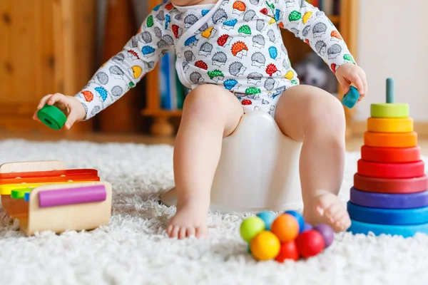 Primer plano de lindo niño pequeño de 12 meses de edad bebé niña sentada en el orinal. —  Fotos de Stock