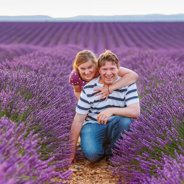 Romantic couple in love in lavender fields in Provence, France. Beautiful young man and woman hugging at sunset. Wedding or engagement. — Stock Photo, Image