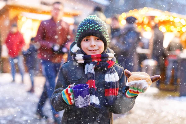 可爱的小男孩在圣诞市场上吃德国香肠 喝着火辣的儿童饮料 德国传统家庭市场上的快乐孩子 穿着五颜六色冬衣的笑男孩 — 图库照片