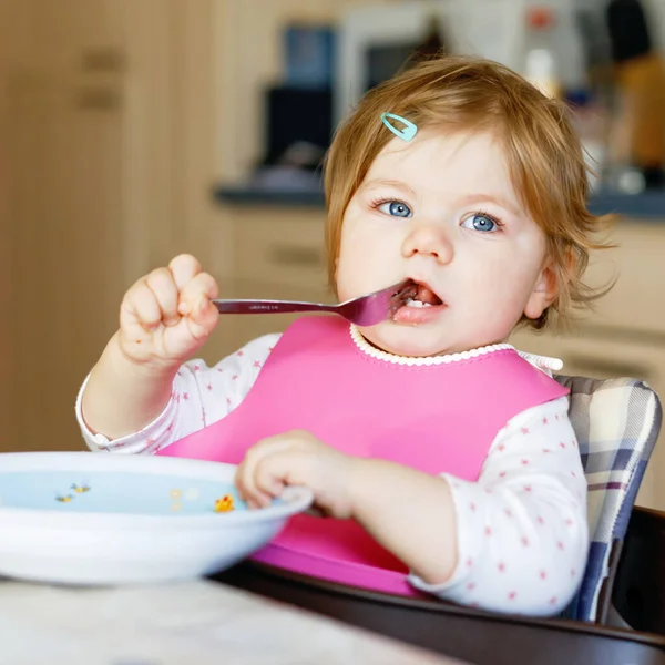 可爱的女婴用勺子、捣碎的蔬菜和浓汤吃饭。食物、儿童、食物和人的概念 — 图库照片