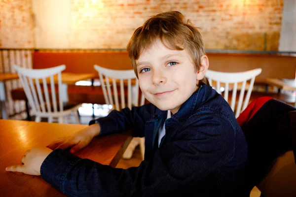 Portrait de mignon petit garçon écolier au restaurant en vacances. Heureux enfant en bonne santé dans un café intérieur. — Photo