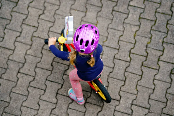 Little toddler girl running with balance bike on summer day. Happy child driving, biking with bicycle, outdoor activity. Happiness, childhood — Stock Photo, Image