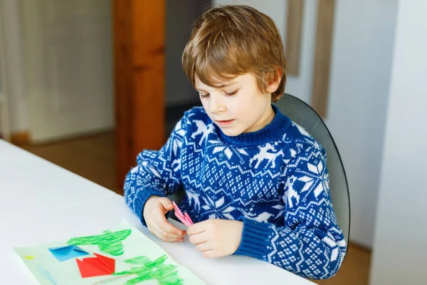 Menino fazendo papel origami flores de tulipa para um cartão postal para o dia das mães ou aniversário. Criança bonito da escola de classe elementar fazendo artesanato — Fotografia de Stock